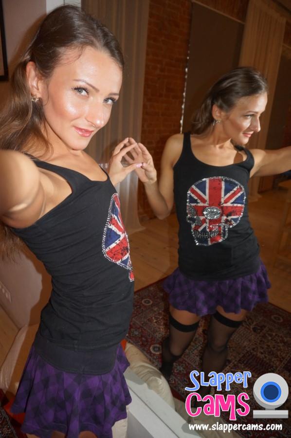 Brit cam girl wearing a pleated skirt and black stockings.